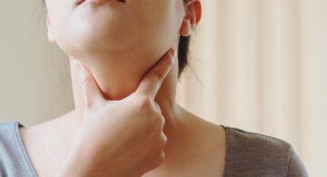 Woman touching her throat area to test thyroid condition
